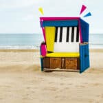 Farbenfrohes Strandkunstwerk aus einer umgestalteten Strandhütte mit Klaviertastatur, bei Kammermusikfest Sylt, kreative und einzigartige Musikevents an der Nordsee in Sylt.